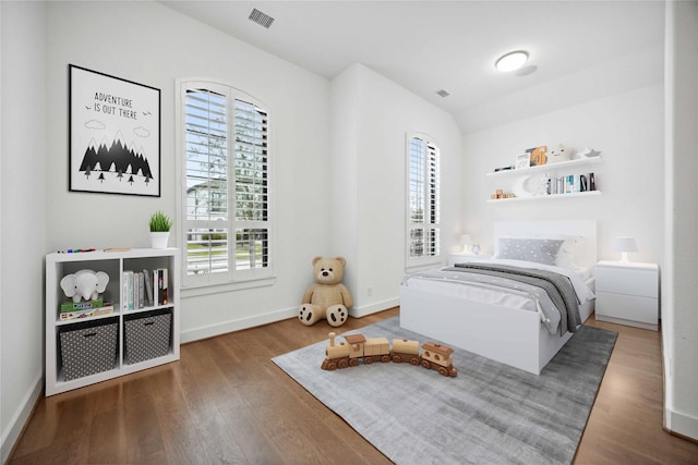 bedroom featuring wood finished floors, visible vents, and multiple windows