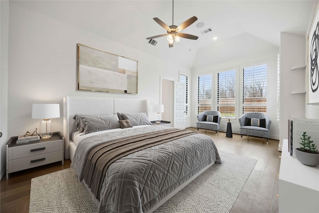 bedroom with vaulted ceiling, a ceiling fan, wood finished floors, and visible vents