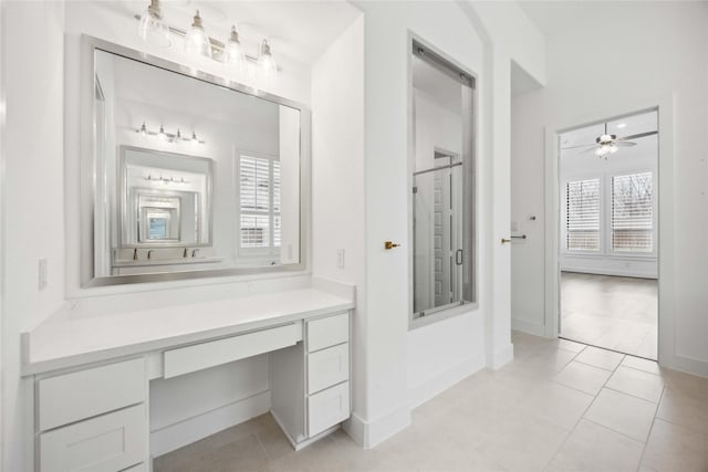 bathroom featuring a ceiling fan, vanity, tile patterned flooring, and a shower