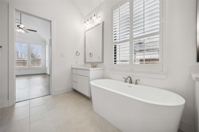 bathroom featuring a soaking tub, vaulted ceiling, vanity, and ceiling fan