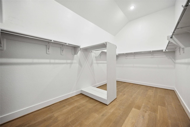 spacious closet featuring light wood-style floors and lofted ceiling