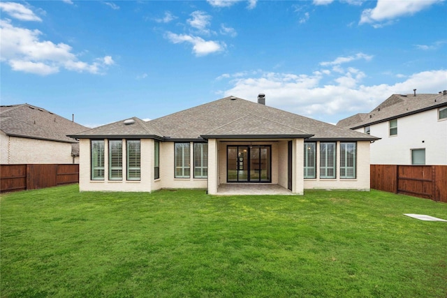 rear view of property with a fenced backyard, roof with shingles, and a yard