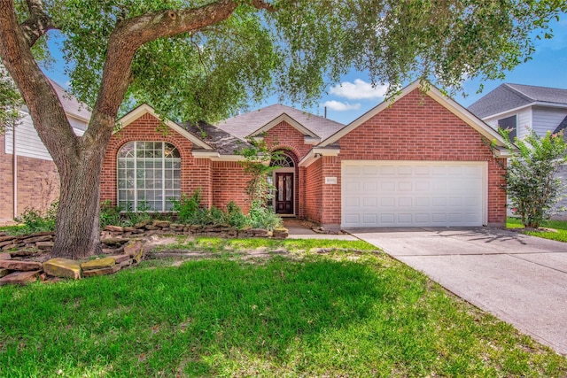 view of front of property featuring a garage, a front yard, concrete driveway, and brick siding