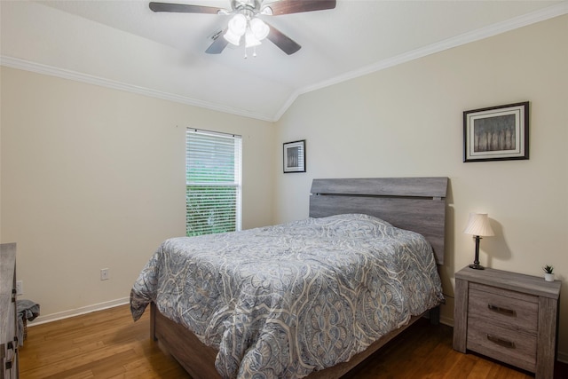 bedroom with baseboards, ceiling fan, dark wood-type flooring, vaulted ceiling, and crown molding