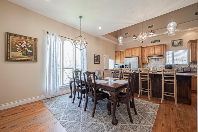 dining area with visible vents, hardwood / wood-style flooring, and baseboards