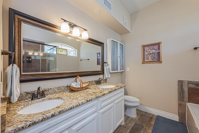 full bathroom featuring double vanity, visible vents, a sink, and wood finished floors