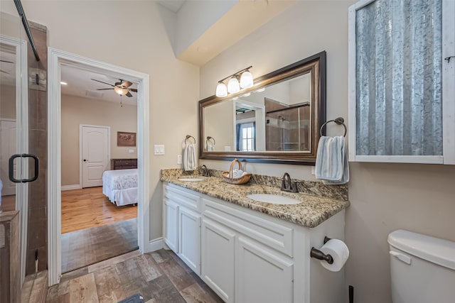 bathroom featuring double vanity, connected bathroom, a sink, and wood finished floors