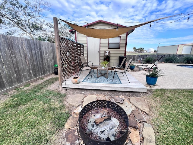 view of yard featuring a fenced backyard, a fire pit, and a deck