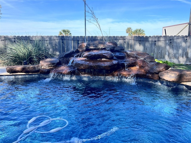 view of swimming pool featuring a swimming pool and fence