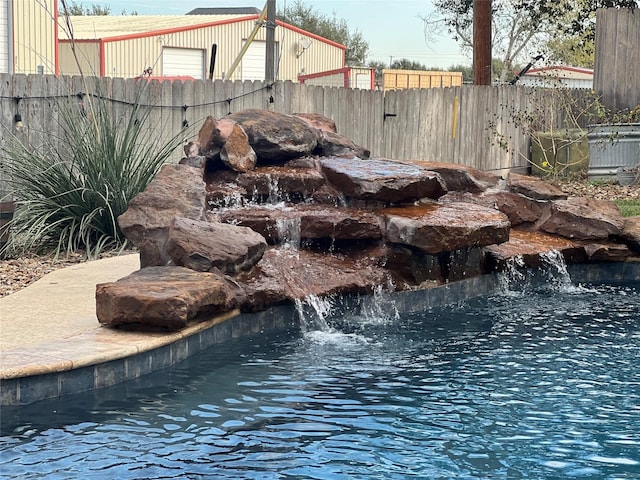 view of swimming pool with fence