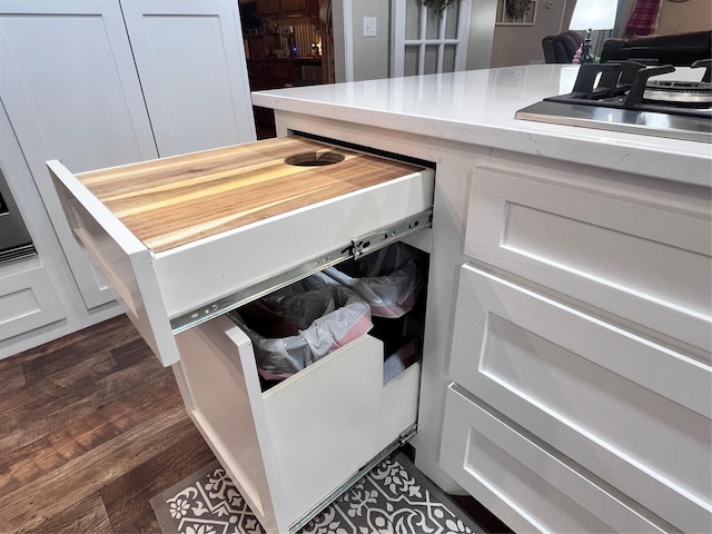 details featuring white cabinetry, dark wood-type flooring, and stainless steel gas stovetop