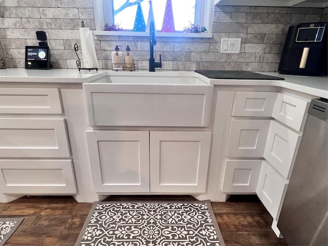 kitchen featuring backsplash, white cabinetry, stainless steel dishwasher, and a sink