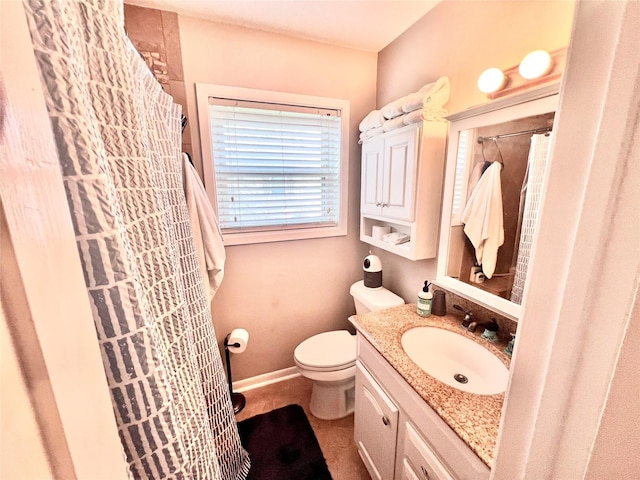 bathroom with vanity, toilet, a shower with curtain, and baseboards