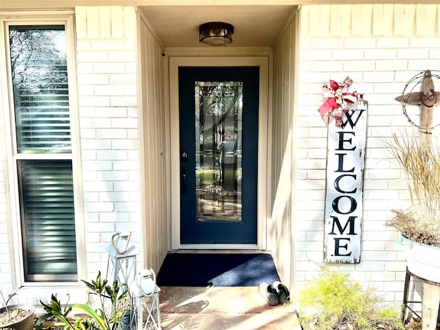 entrance to property featuring brick siding