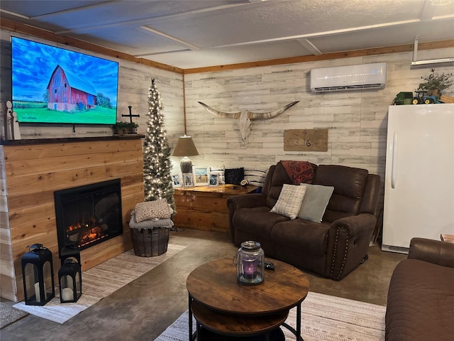 living area featuring finished concrete floors, wood walls, a wall mounted air conditioner, and a glass covered fireplace