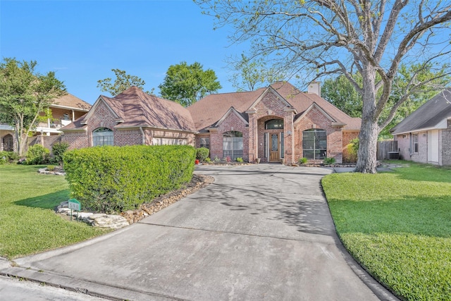 590 Edgewood Dr, Montgomery, TX 77356 - traditional-style house with brick siding, a chimney, and driveway