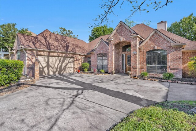 590 Edgewood Dr, Montgomery, TX 77356 - traditional-style house with brick siding, driveway, a chimney, a garage, and a shingled roof
