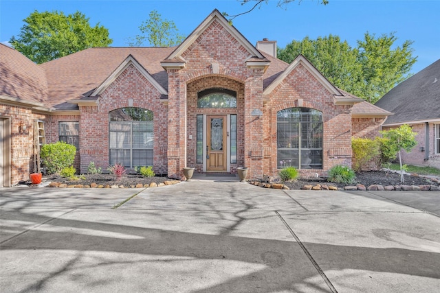 590 Edgewood Dr, Montgomery, TX 77356 - view of front of home with brick siding, a chimney, and roof with shingles