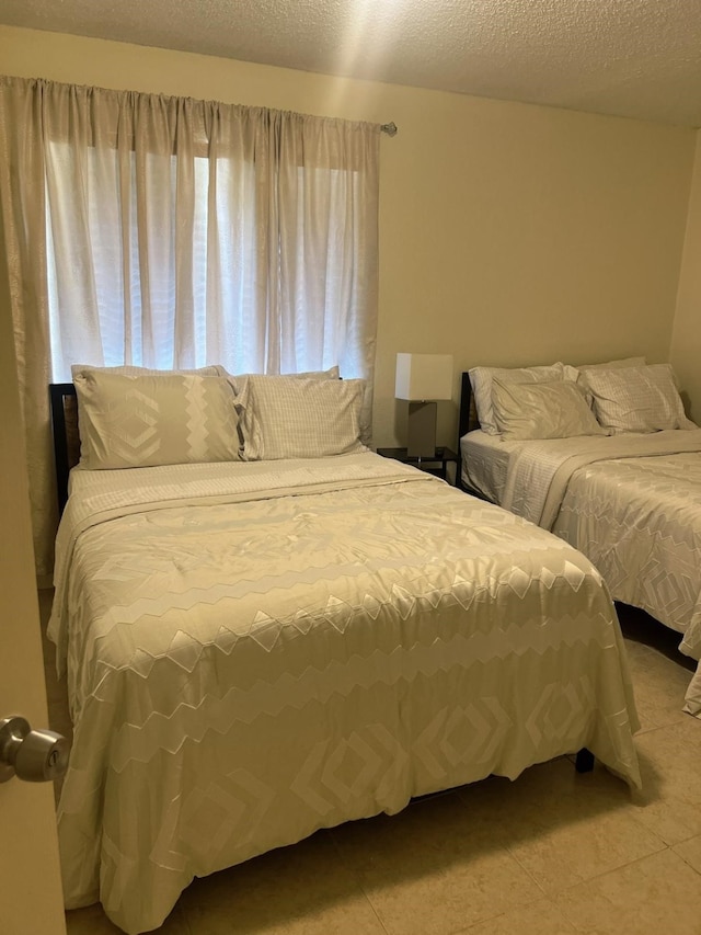 bedroom featuring a textured ceiling and light tile patterned flooring