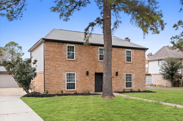 colonial-style house featuring concrete driveway, a front lawn, and a chimney