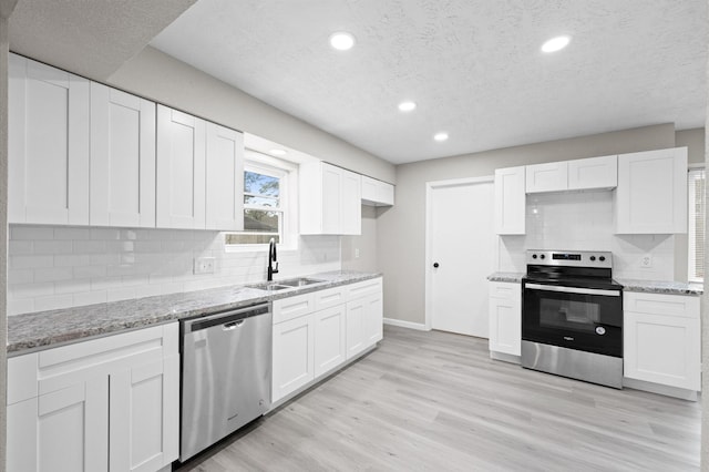 kitchen featuring white cabinets, stainless steel appliances, and a sink