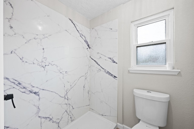 bathroom with a stall shower, a textured ceiling, and toilet