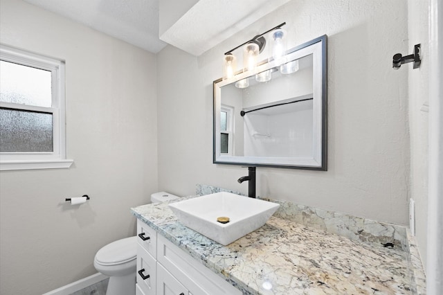 bathroom featuring baseboards, vanity, and toilet