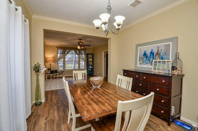 dining area featuring baseboards, dark wood finished floors, visible vents, and crown molding