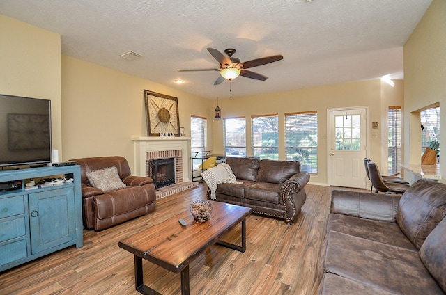 living area with a wealth of natural light, visible vents, and wood finished floors