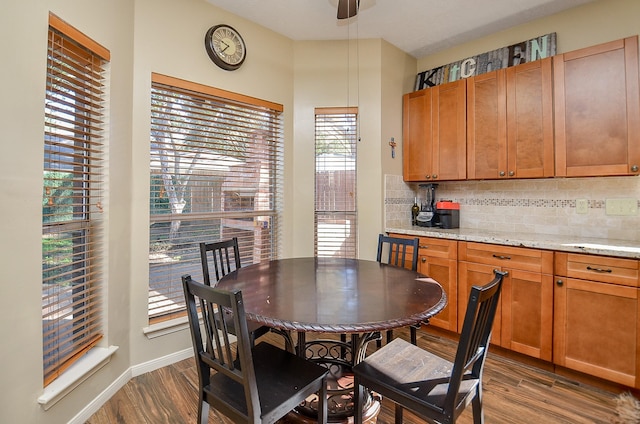 dining area with dark wood-style flooring, ceiling fan, and baseboards