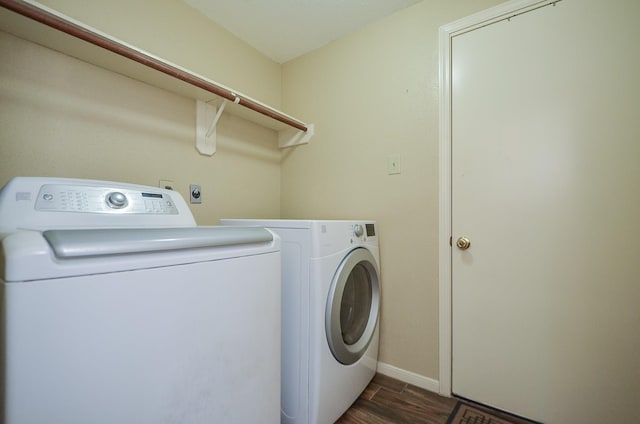 laundry room featuring laundry area, baseboards, dark wood finished floors, and washing machine and clothes dryer