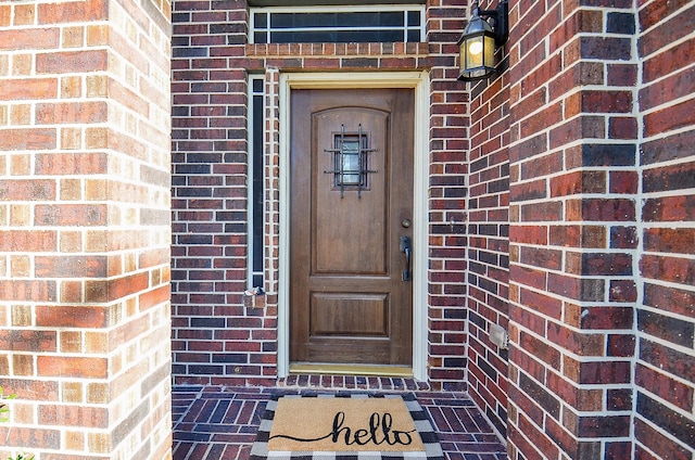 entrance to property featuring brick siding