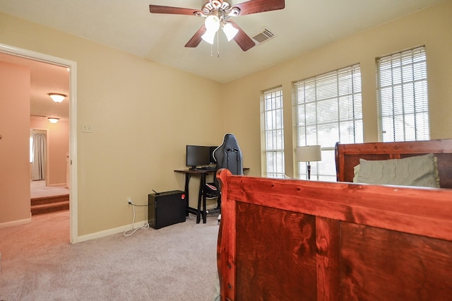 bedroom featuring baseboards, visible vents, ceiling fan, and light colored carpet