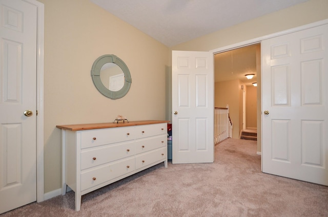 unfurnished bedroom with lofted ceiling and light colored carpet