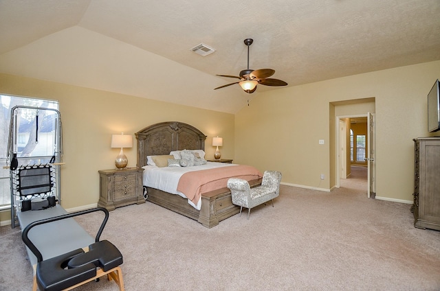 bedroom featuring lofted ceiling, multiple windows, visible vents, and light colored carpet