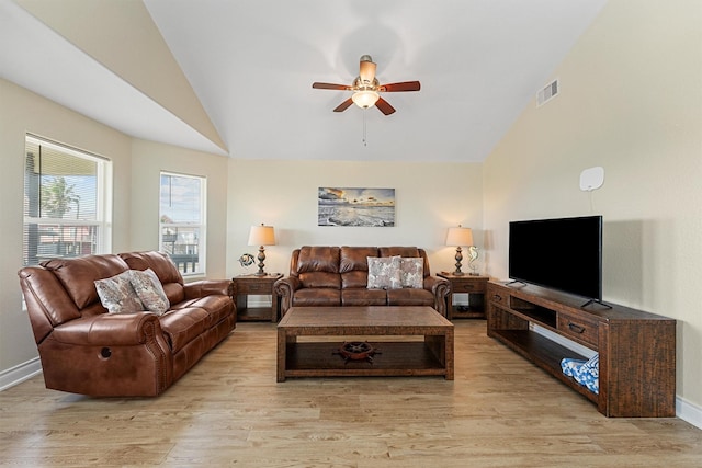 living area featuring visible vents, light wood-style floors, a ceiling fan, high vaulted ceiling, and baseboards