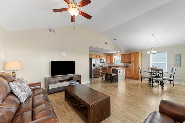 living room featuring light wood finished floors, baseboards, visible vents, high vaulted ceiling, and ceiling fan with notable chandelier