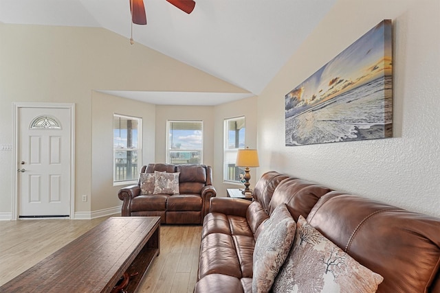 living room with light wood-style floors, lofted ceiling, ceiling fan, and baseboards