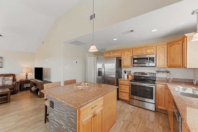 kitchen featuring stainless steel appliances, visible vents, light wood-style floors, open floor plan, and a sink