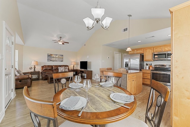 dining area with light wood-style floors, visible vents, high vaulted ceiling, and ceiling fan with notable chandelier