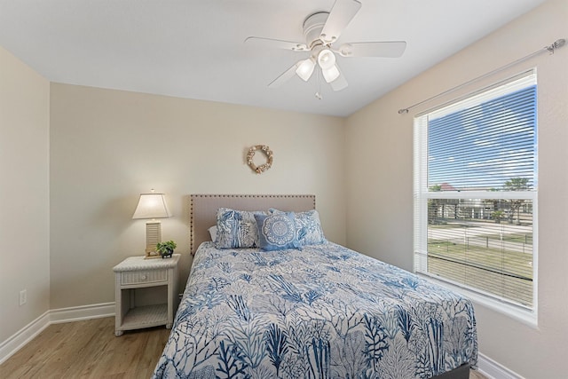 bedroom with ceiling fan, baseboards, and wood finished floors