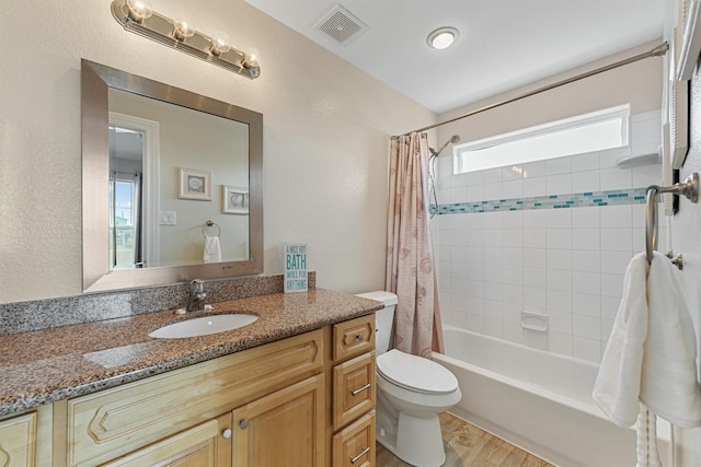 bathroom with toilet, shower / tub combo, wood finished floors, vanity, and visible vents