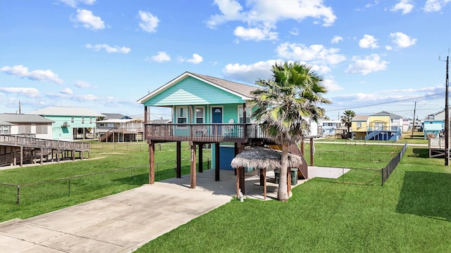 view of property's community featuring a lawn, fence, a carport, a residential view, and driveway