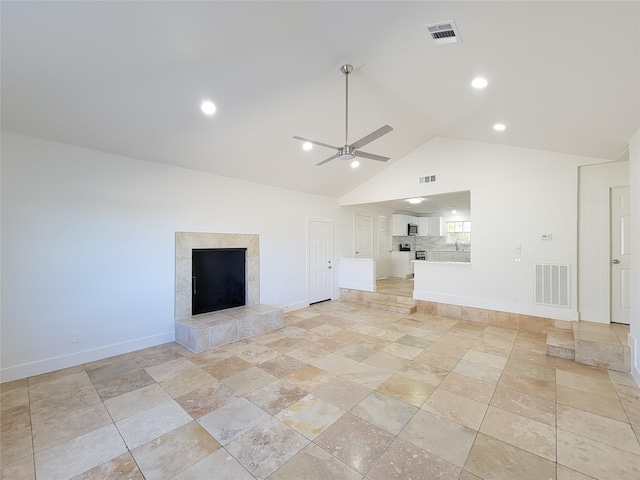 unfurnished living room with ceiling fan, visible vents, and a tile fireplace