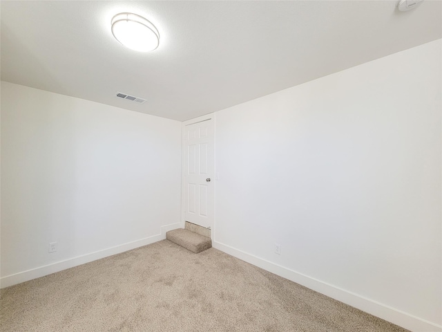 unfurnished room featuring carpet, visible vents, and baseboards