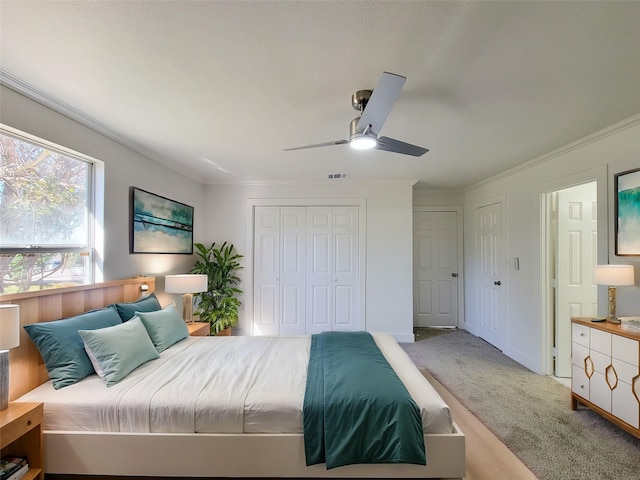 bedroom with ornamental molding, carpet, visible vents, and a ceiling fan