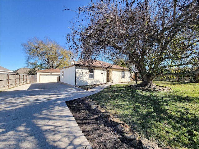 view of front of home with a garage, fence, a front lawn, and stucco siding