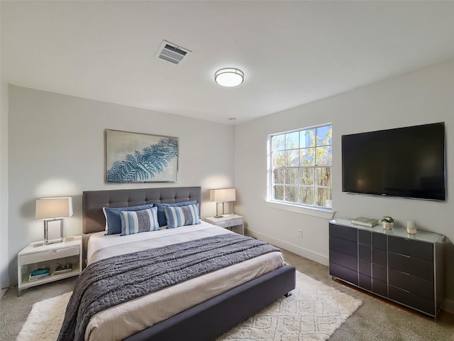 carpeted bedroom featuring visible vents and baseboards