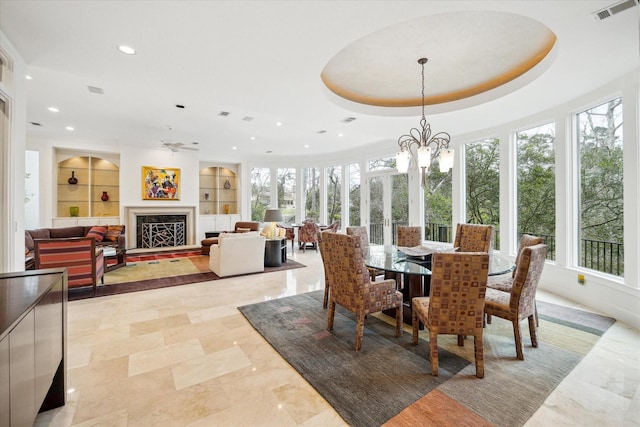 dining room with built in shelves, a fireplace, visible vents, and recessed lighting