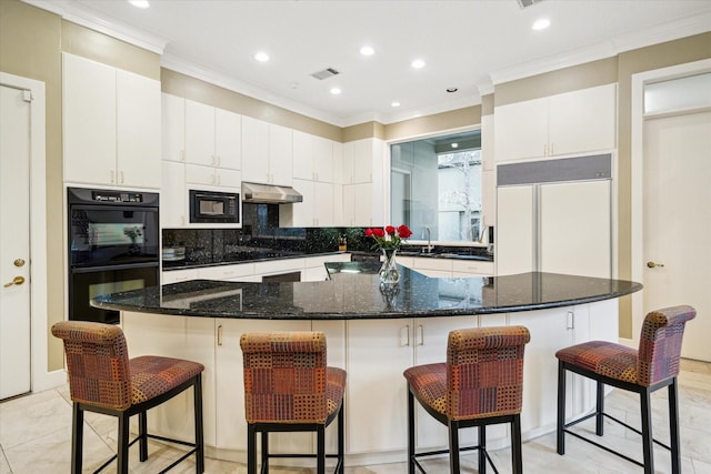 kitchen with a center island, white cabinets, under cabinet range hood, and black appliances